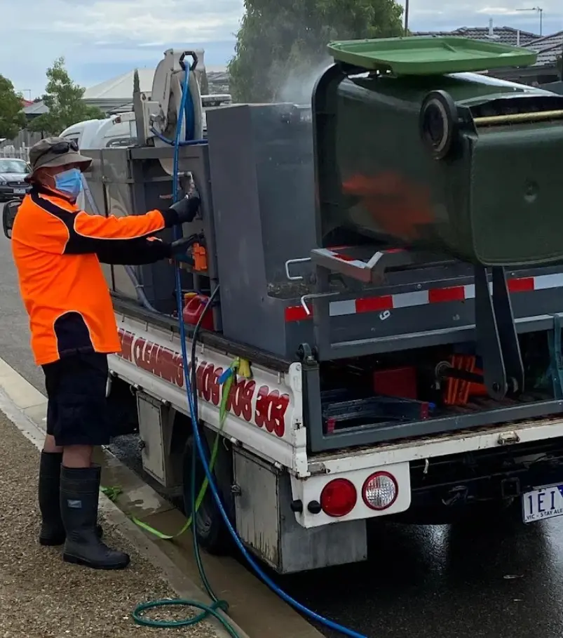 Steve from The Bin Doctor cleaning a wheelie bin at the kerb