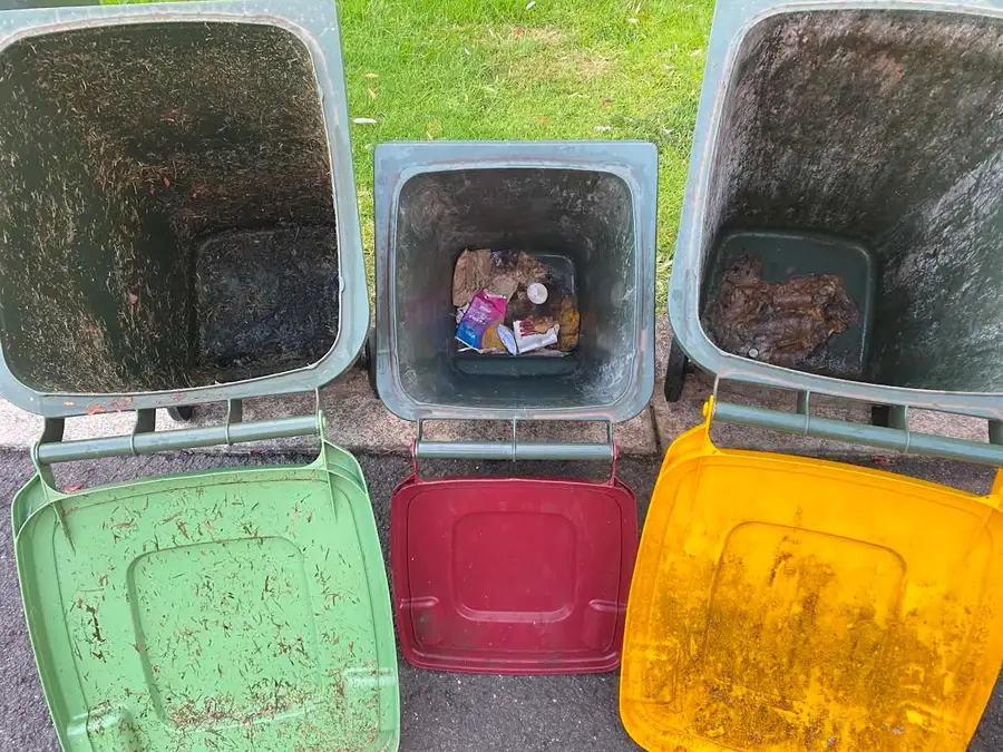 The same three wheelie bins before cleaning — grime, residue and leftover waste inside