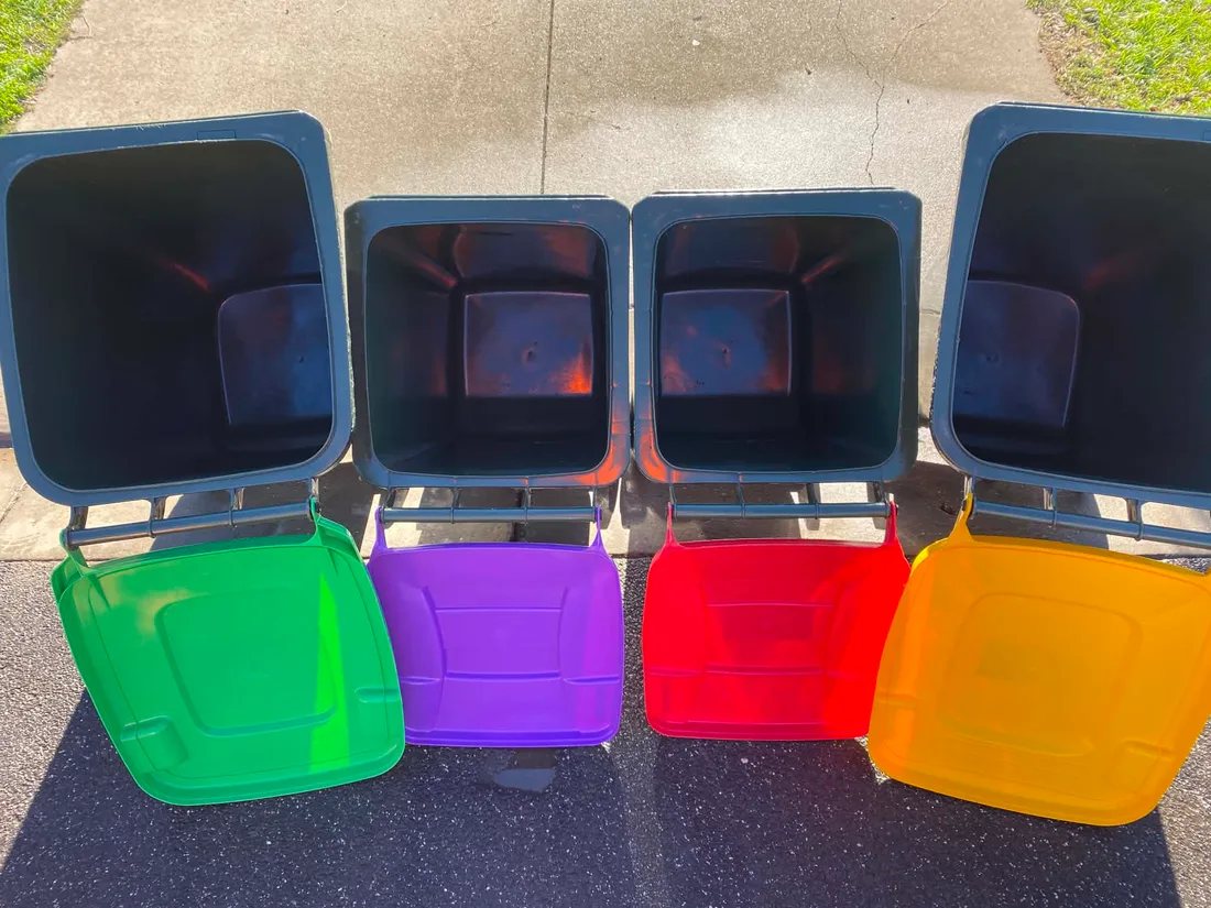 The same four wheelie bins spotless after cleaning